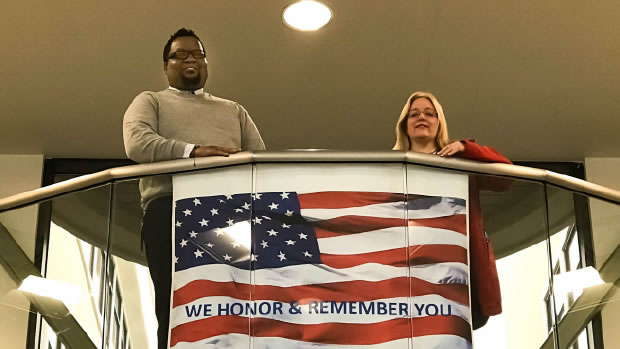 Mareco Smith and Denise Christiansen standing at top of stairs with American flag