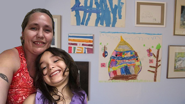 Shayne Tackett and daughter in front of daughter's artwork on the wall