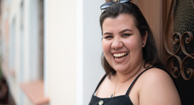 Bella, in front of a building, laughing