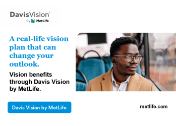 A man wearing glasses and looking out the window on a bus.