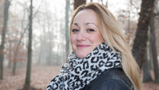 Verduva with a leopard patterned scarf with autumn trees in the background
